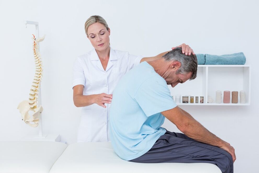 врач осматривает спину с остеохондрозом